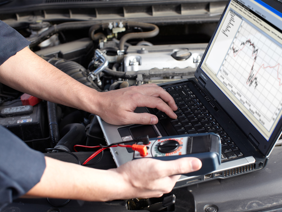 Mechanic performing vehicle diagnostics using specialist diagnostic equipment
